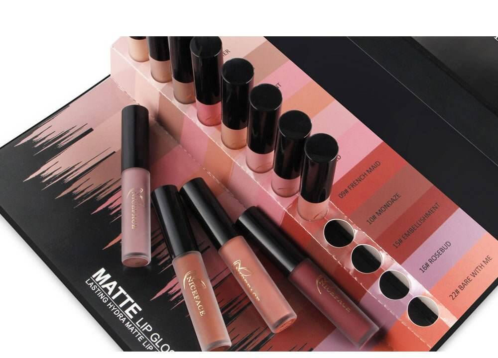 12-color lip gloss set displayed with various shades in packaging on a stylish black background.